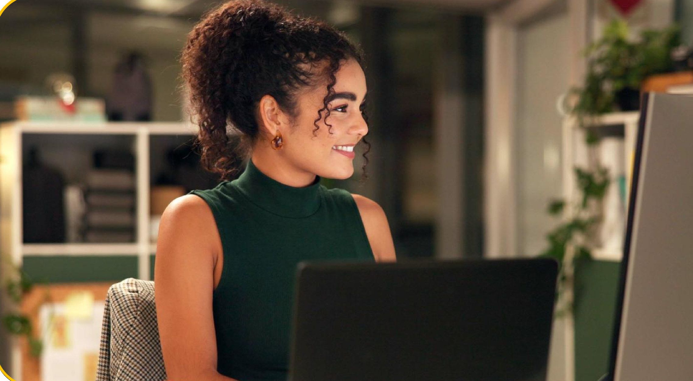 Profesional sonriendo mientras trabaja en su computadora